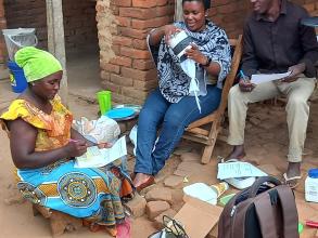 Three community members are being trained to trap, identify, and record mosquito data for a citizen science project.
